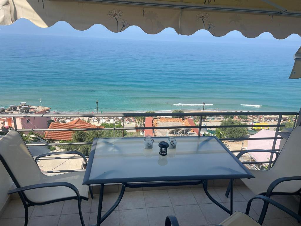 a table on a balcony with a view of the ocean at Gakis in Loutsa