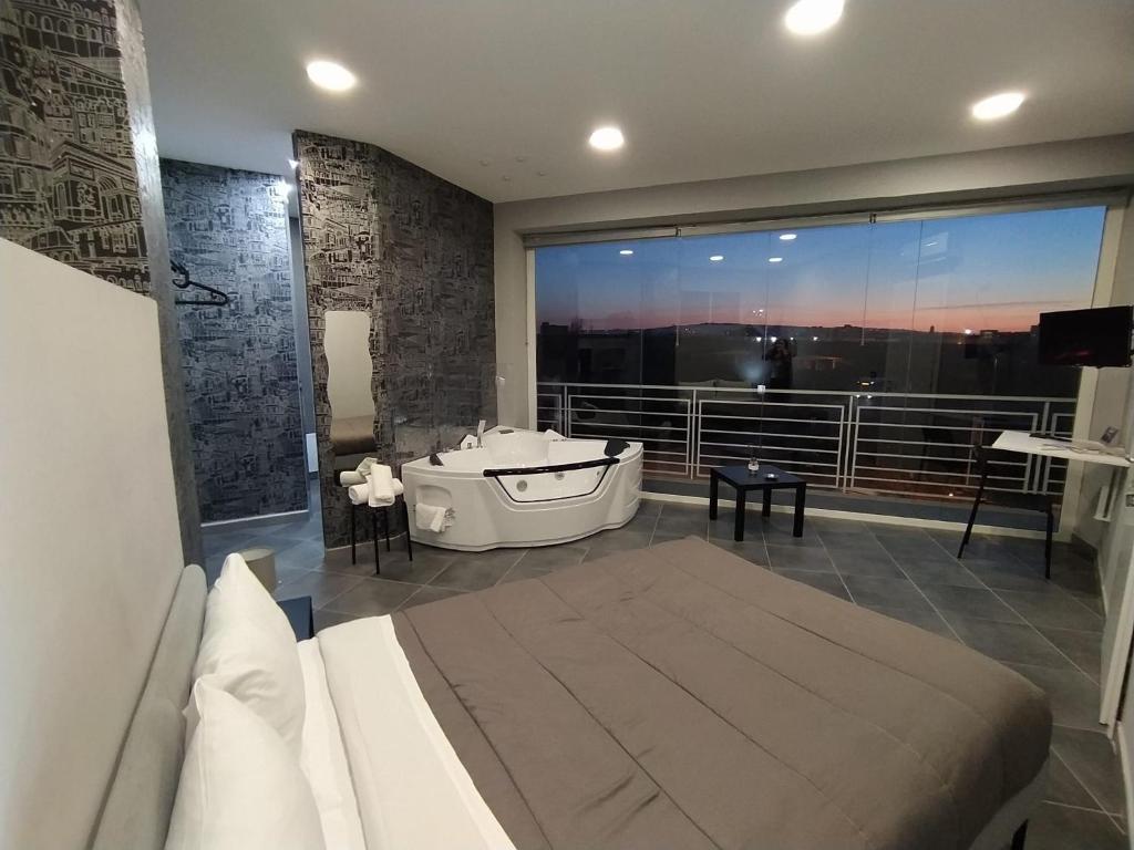 a bedroom with a bath tub and a large window at Living in Casoria