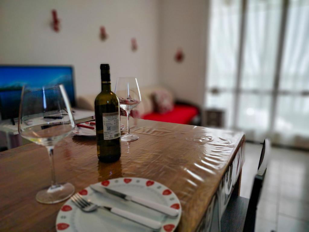 a table with a bottle of wine and two glasses at Sweetheart Apartment in Busto Arsizio