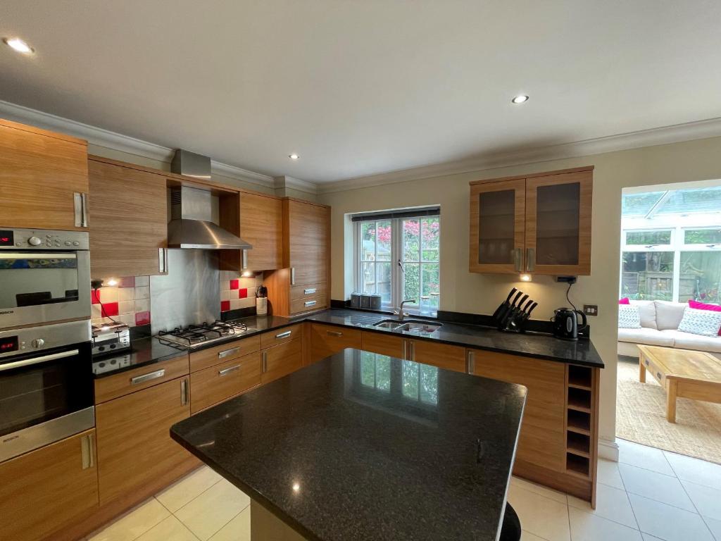 a kitchen with wooden cabinets and a black counter top at Henley - Luxurious Spacious Four Bedroom Two Bath in Henley on Thames