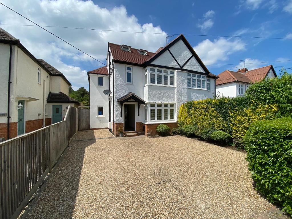 a white house with a fence and a driveway at Ascot stunning and modern 4 bedroom town house with 156 sq ft garden office 28 in Ascot