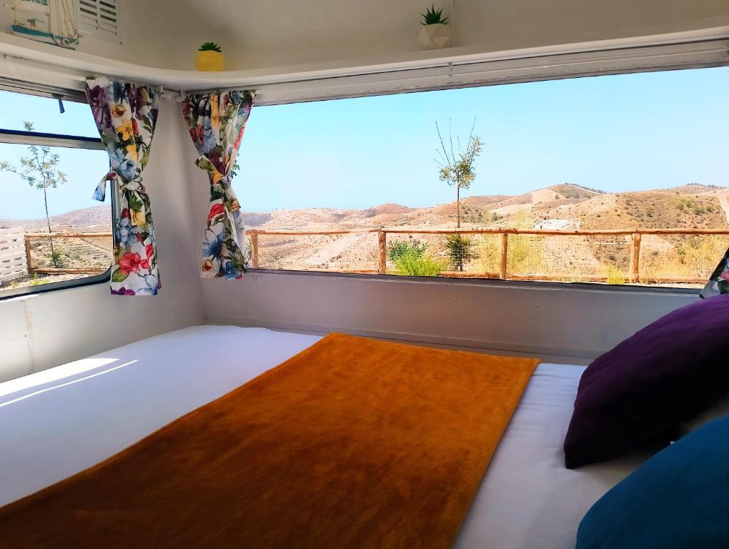 Tropical Dreams Motril في Los Tablones: سرير في غرفة مع نافذة كبيرة