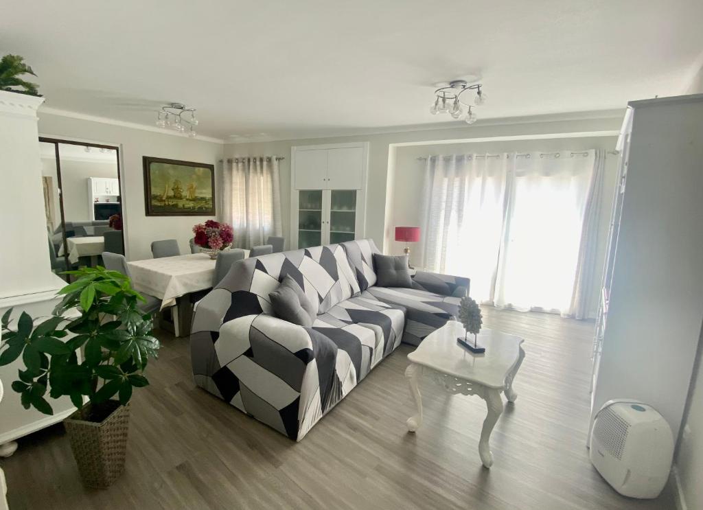 ein Wohnzimmer mit einem Sofa und einem Tisch in der Unterkunft casa hilario in Nazaré