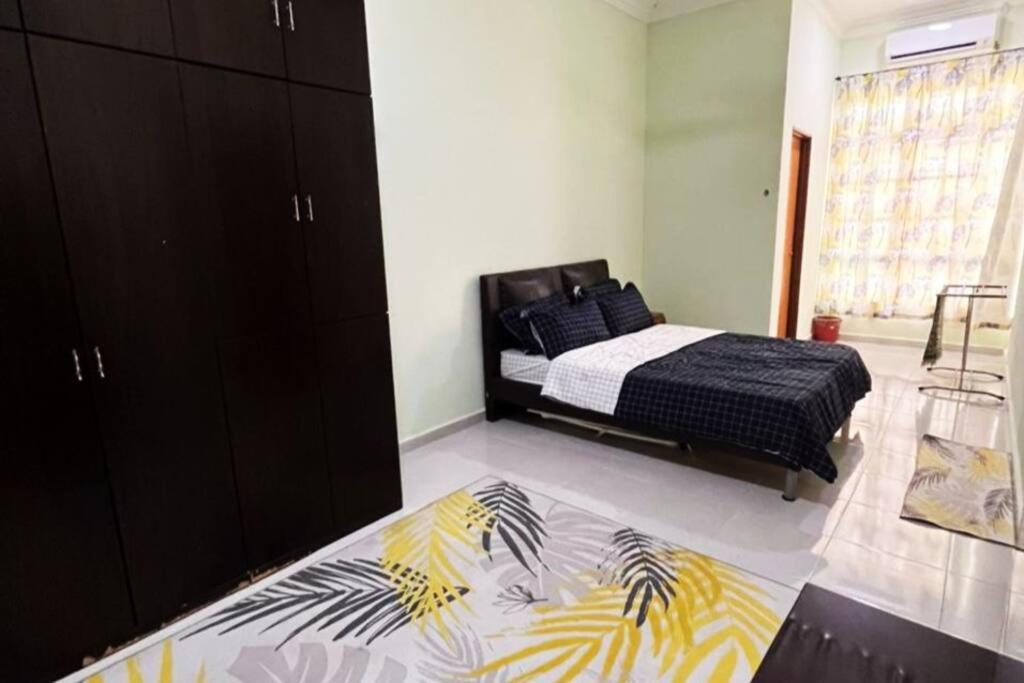 1 dormitorio con 1 cama con manta negra y amarilla en Kayak D'bali Homestay en Pasir Puteh