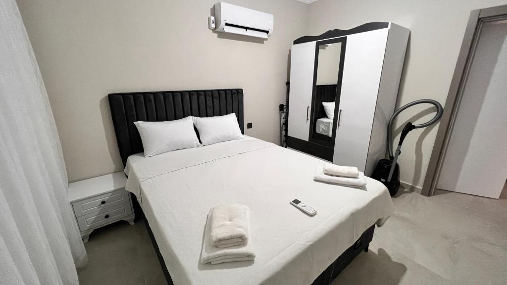 1 dormitorio con 1 cama con sábanas blancas y espejo en Selinti City Tatil Evleri1&1, en Gazipasa