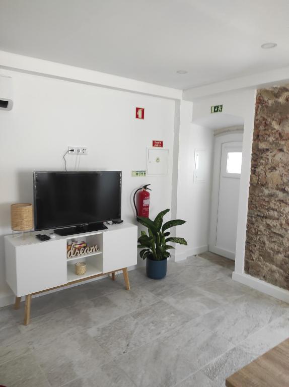 a living room with a flat screen tv on a white cabinet at Casa da Maria in Constância