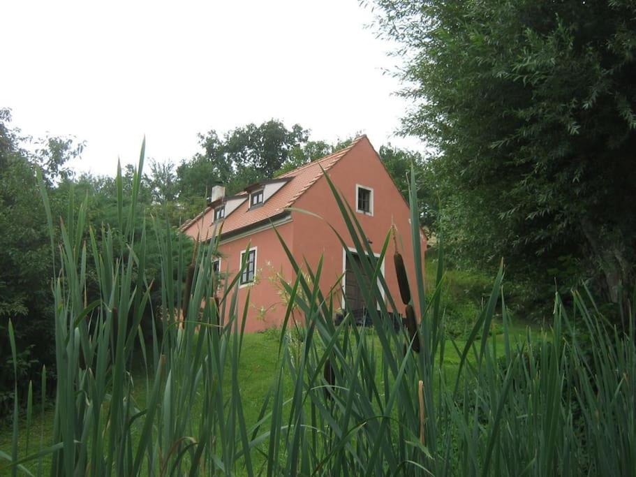 una casa roja en medio de un campo en Dům na Krásné ve Středohoří, 