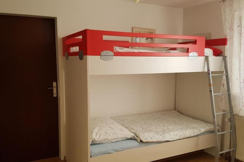 a red bunk bed in a small room with a ladder at Kellergeschoss Wohnung Moto GP Wochenende in Kraubath an der Mur