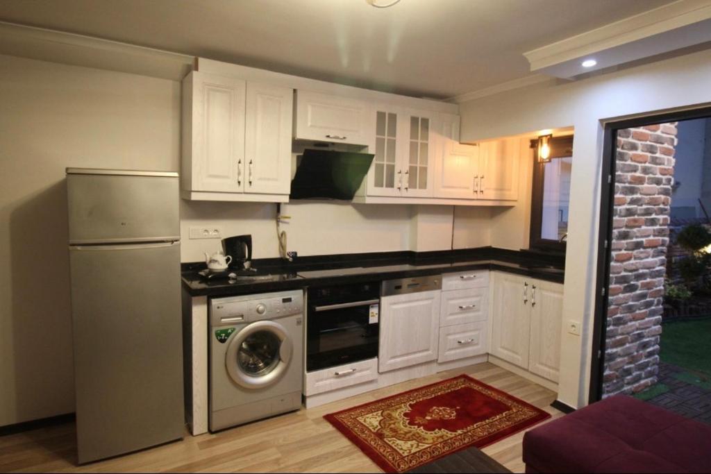 cocina con armarios blancos y lavadora en Ultima apartment, en Estambul