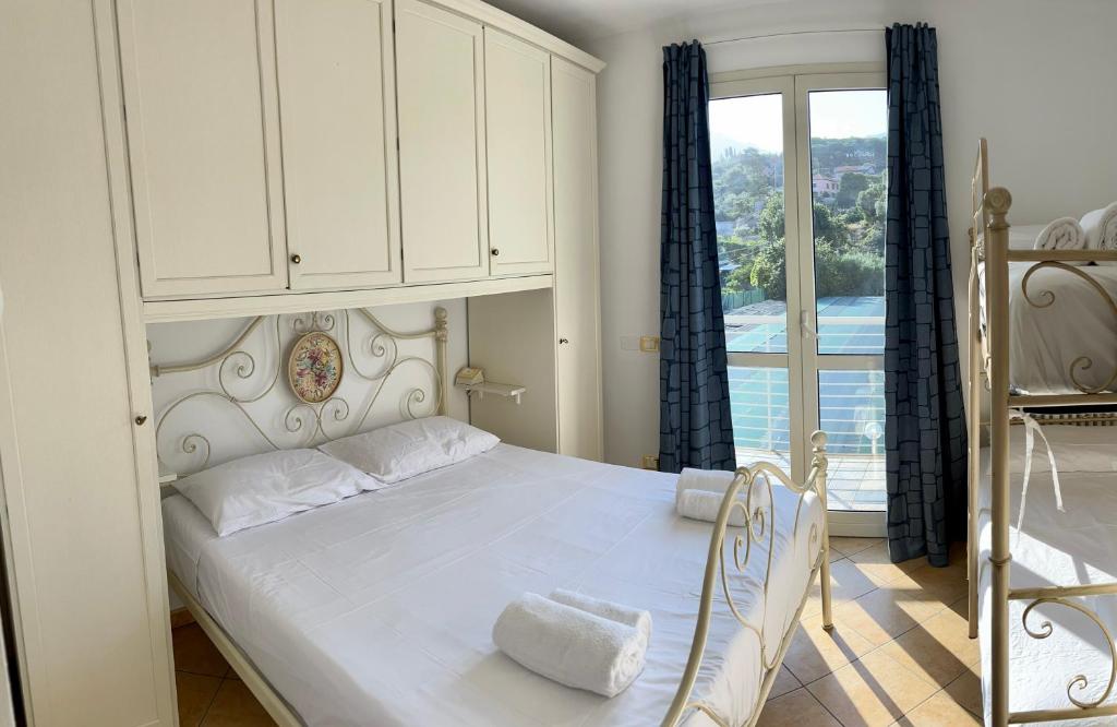 ein Schlafzimmer mit einem weißen Bett und einem Fenster in der Unterkunft Casa Anselmo in Loano