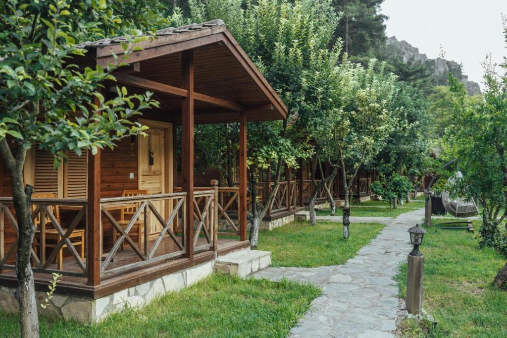 eine kleine Holzhütte in einem Park mit Bäumen in der Unterkunft ALANYA BUNGALOW EVLERİ / RESTAURANT in Asmaca