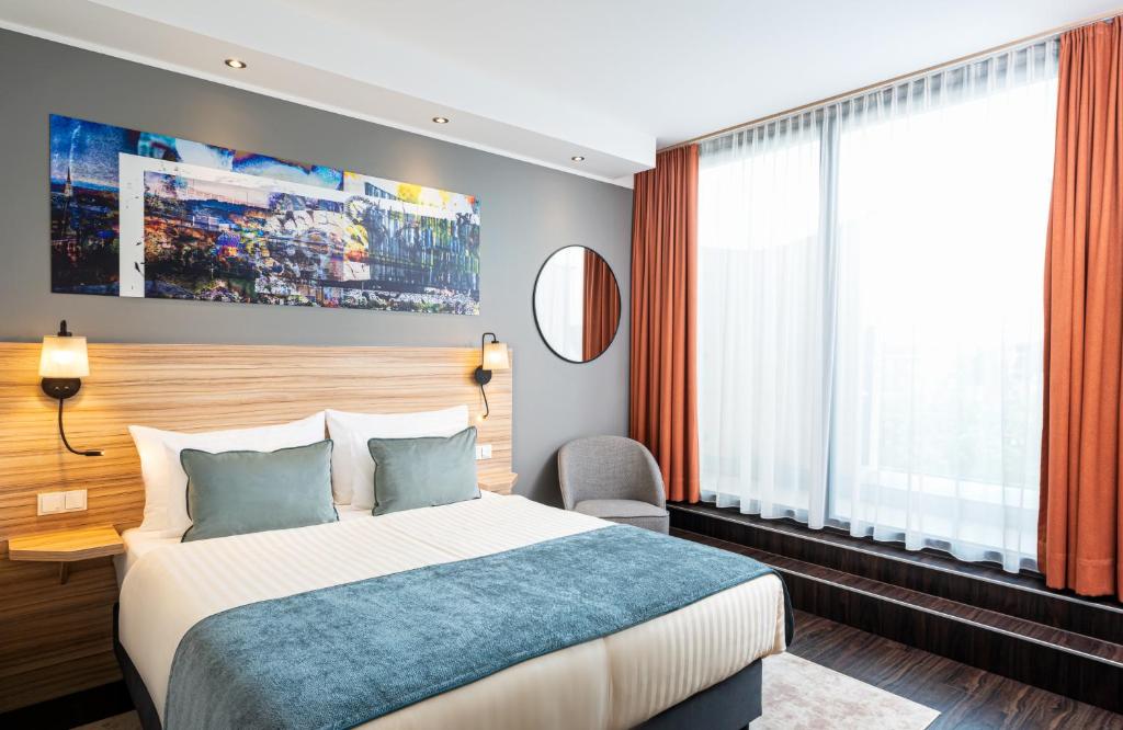 a hotel room with a bed and a large window at Leonardo Boutique Hotel Linz City Center in Linz
