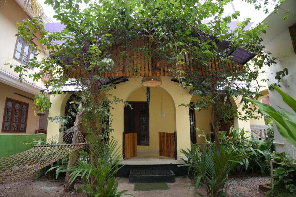 an entrance to a house with a tree in front at Cascara Beach Resort in Varkala