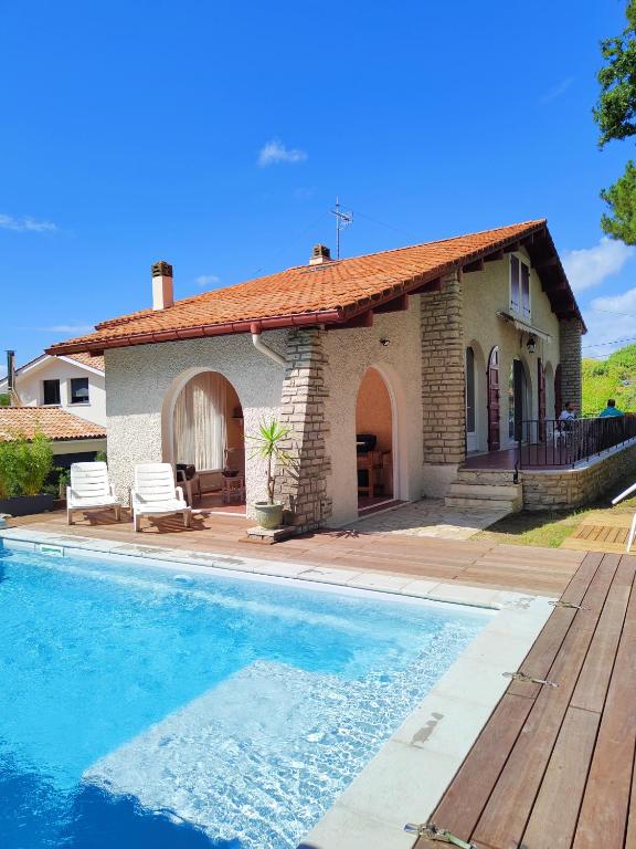 une maison avec une piscine devant une maison dans l'établissement Villa avec piscine, à Capbreton