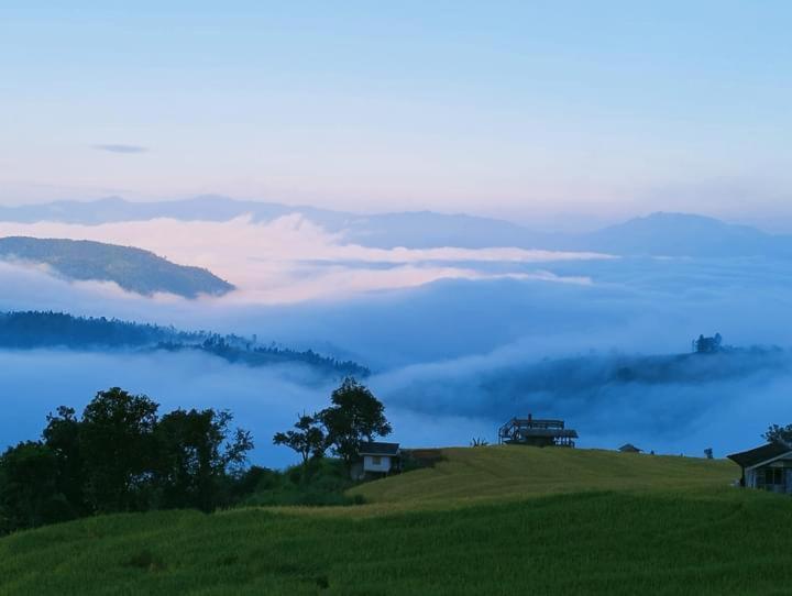 a hillside with a view of a fog covered valley at บ้านพักน้องนํ้าพุโฮมสเตย์ in Ban Yang Mae Uam