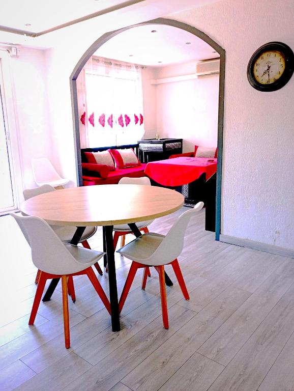 Habitación con mesas, sillas y reloj en appartement ABI, en La Seyne-sur-Mer