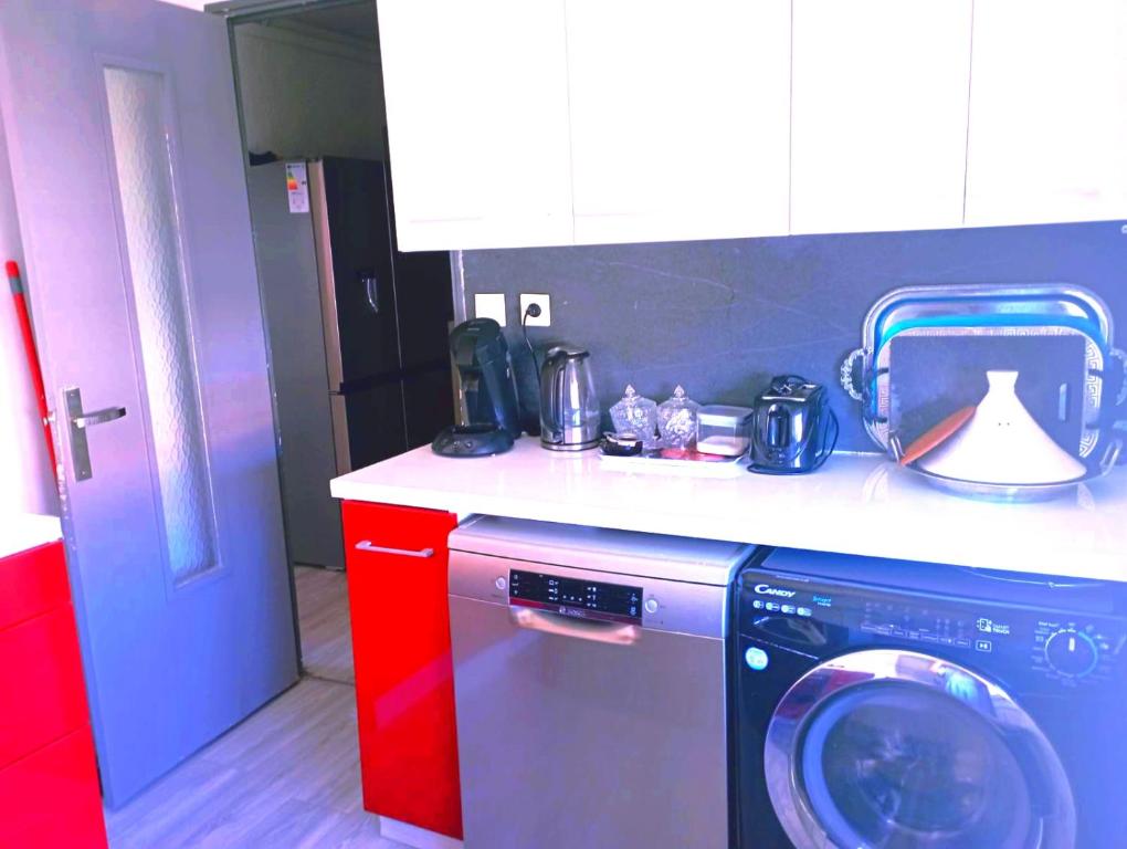 y cocina con lavadora y armarios rojos. en appartement ABI, en La Seyne-sur-Mer