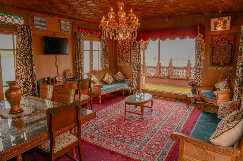 a living room with a chandelier and a table at Golden Flower Heritage Houseboat in Srinagar