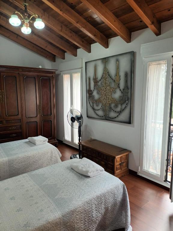 a bedroom with two beds and a painting on the wall at O Cobo Vacacional in Padrón