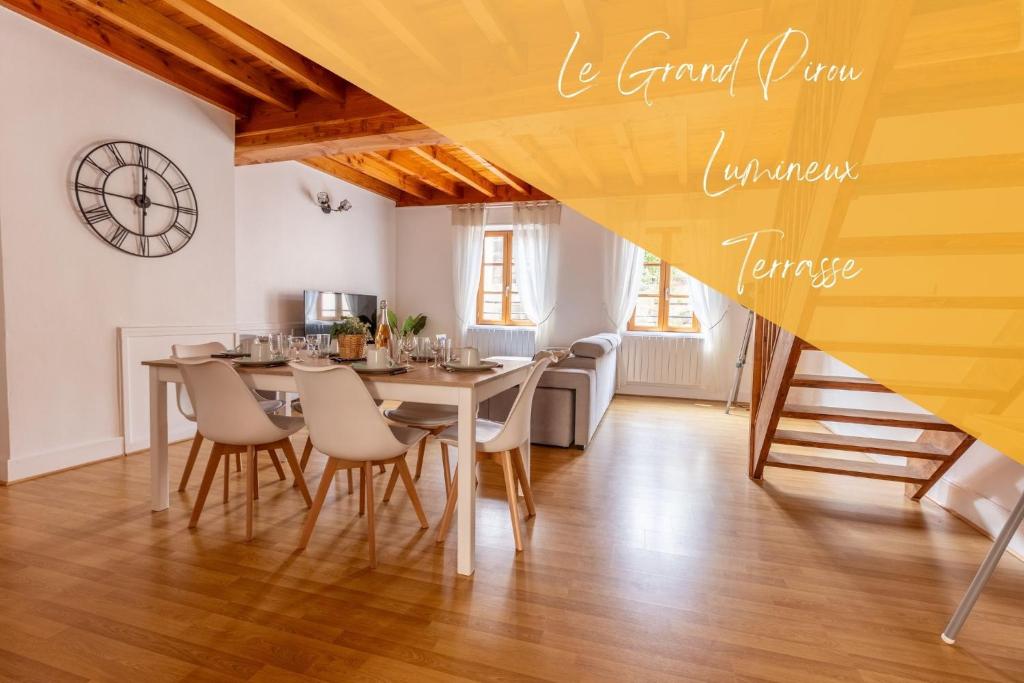 uma sala de jantar com mesa e cadeiras e um relógio em Le Grand Pirou # Lumineux # Halte Auvergne em Thiers