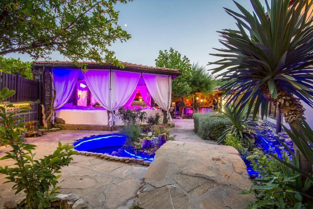 a backyard with a house with purple lighting at Coral Guest House in Obzor