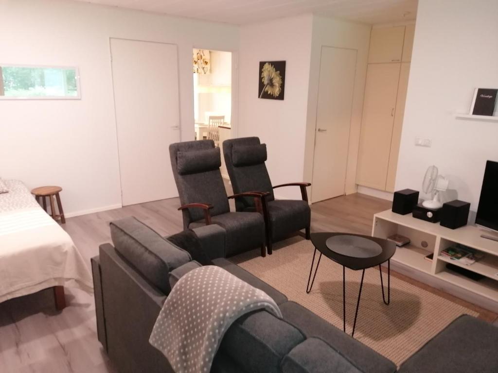 a living room with a couch and two chairs at Majoituspalvelu Nurmi Apartment Peipontie 3 A Saunallinen Huoneisto in Raahe