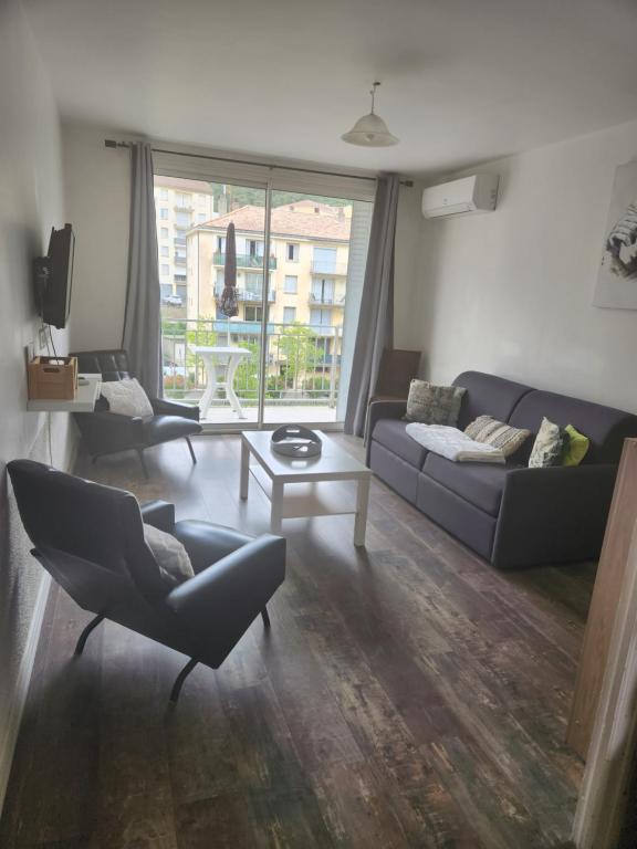 un salon avec un canapé, des chaises et une table dans l'établissement Agréable Appartement F3 climatisé, à Corte