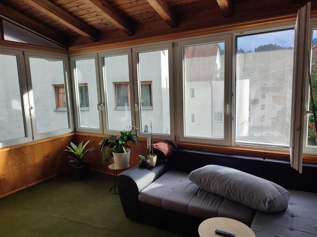 ein Wohnzimmer mit einem Sofa vor den Fenstern in der Unterkunft Apartment Salve & Sonne in Hopfgarten im Brixental