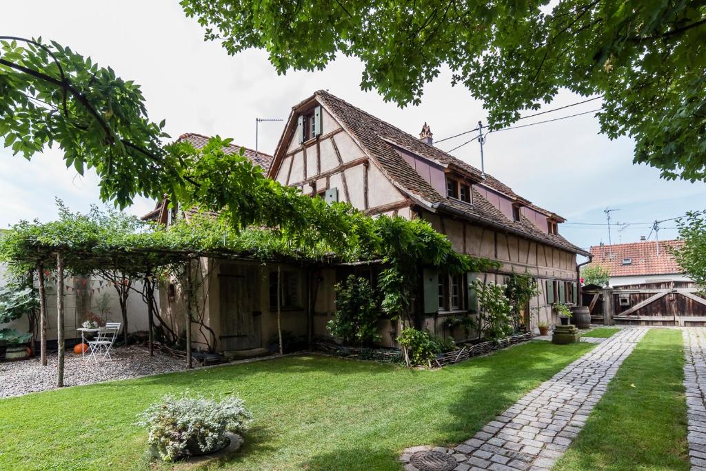 an old house with a green yard at Maison Alsacienne 6p in Illkirch-Graffenstaden