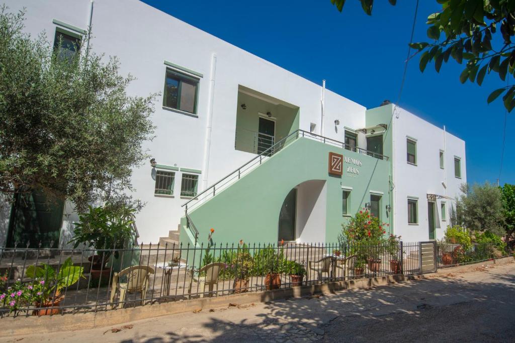 un edificio blanco y verde con una valla en Xenios Zeus Apartments en Kíssamos