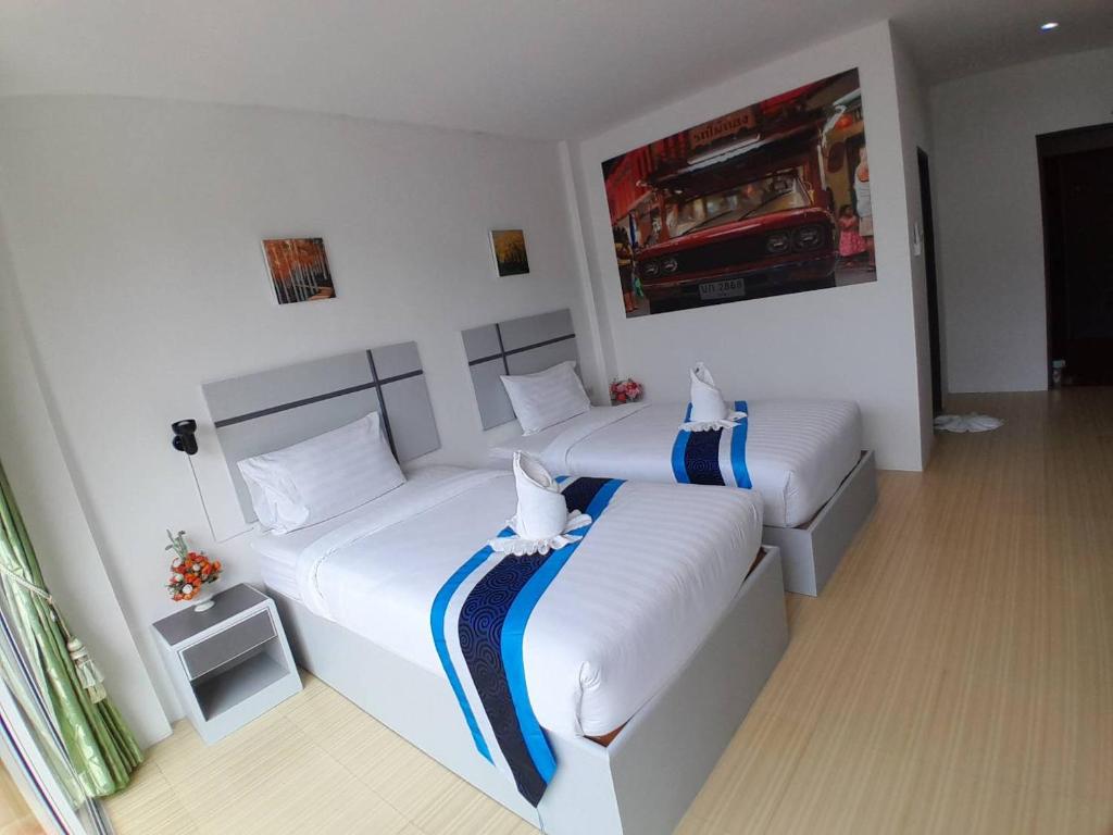 a bedroom with two beds and a painting on the wall at Toto Residence in Ao Nang Beach