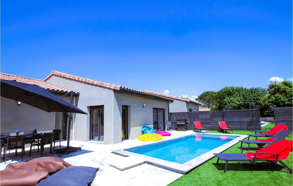 een achtertuin met een zwembad met stoelen en een tafel bij 4 Bedroom Stunning Home In Clon Dandran in Cléon-dʼAndran
