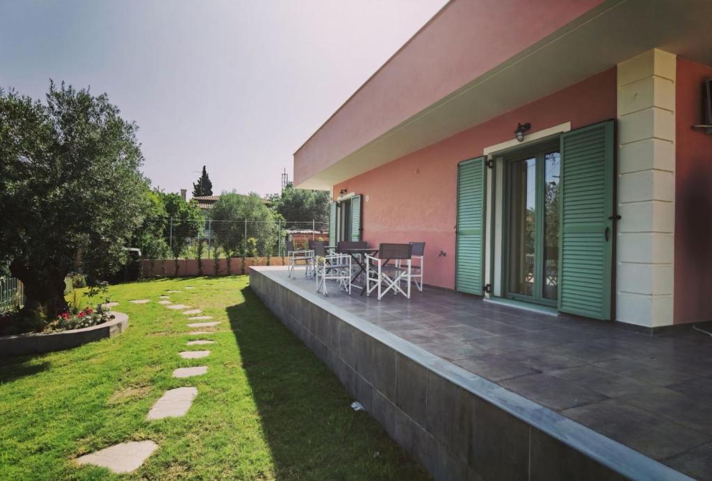 een balkon van een huis met een tafel en stoelen bij Elpida Suites in Nea Iraklia