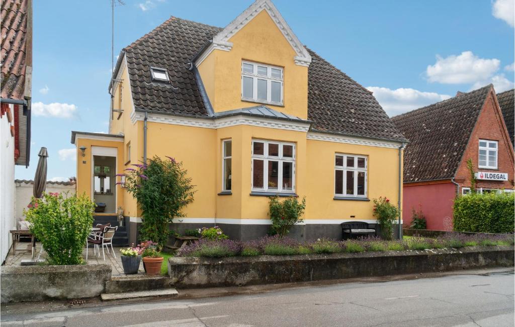 a yellow house with a black roof at 3 Bedroom Lovely Home In Sams in Nordby