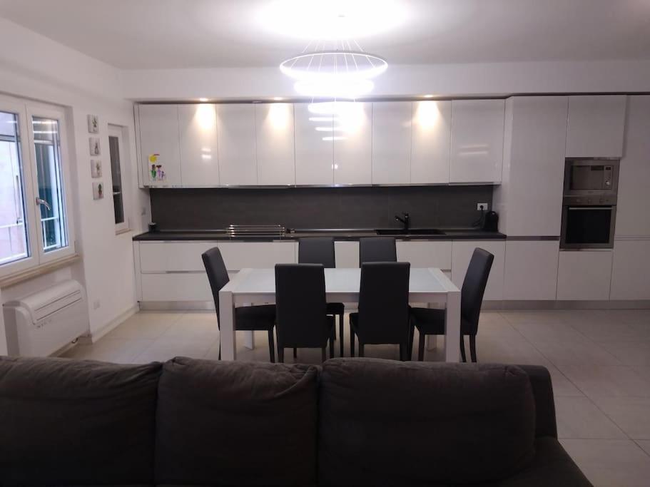 a dining room with a table and chairs and a kitchen at Appartamento all ‘Argentario Porto Santostefano Gr in Porto Santo Stefano