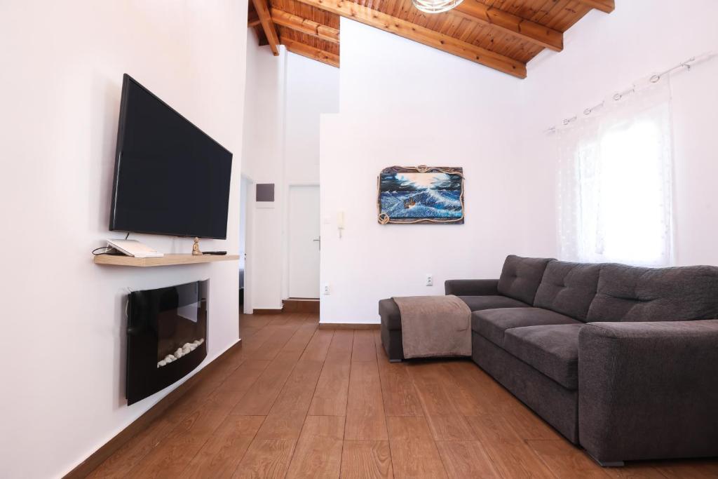a living room with a couch and a flat screen tv at Casa San Pierro in Corfu