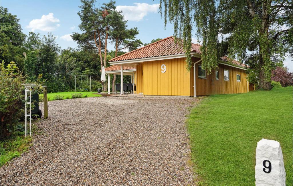 HejlsにあるBeautiful Home In Hejls With 4 Bedrooms, Sauna And Wifiの砂利道付黄色の家