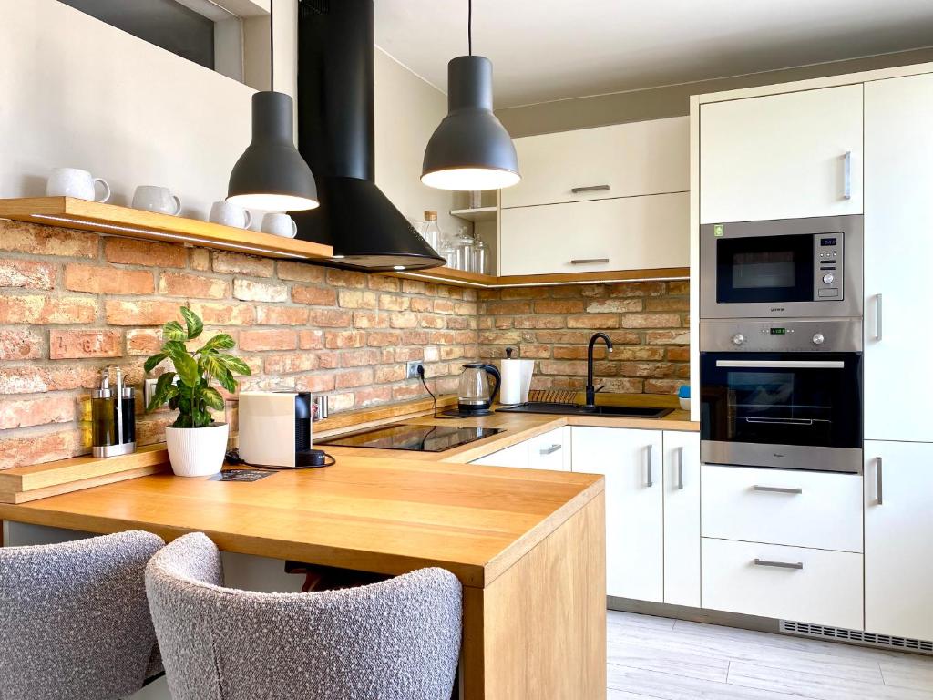 a kitchen with white cabinets and a wooden table at B10 Apartments Bulvár in Žilina