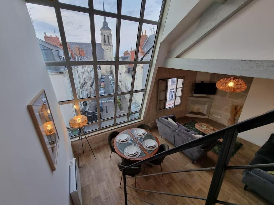 einen Blick über ein Wohnzimmer mit einem großen Fenster in der Unterkunft Superbe duplex La Verrière chic, cosy et spacieux in Saumur