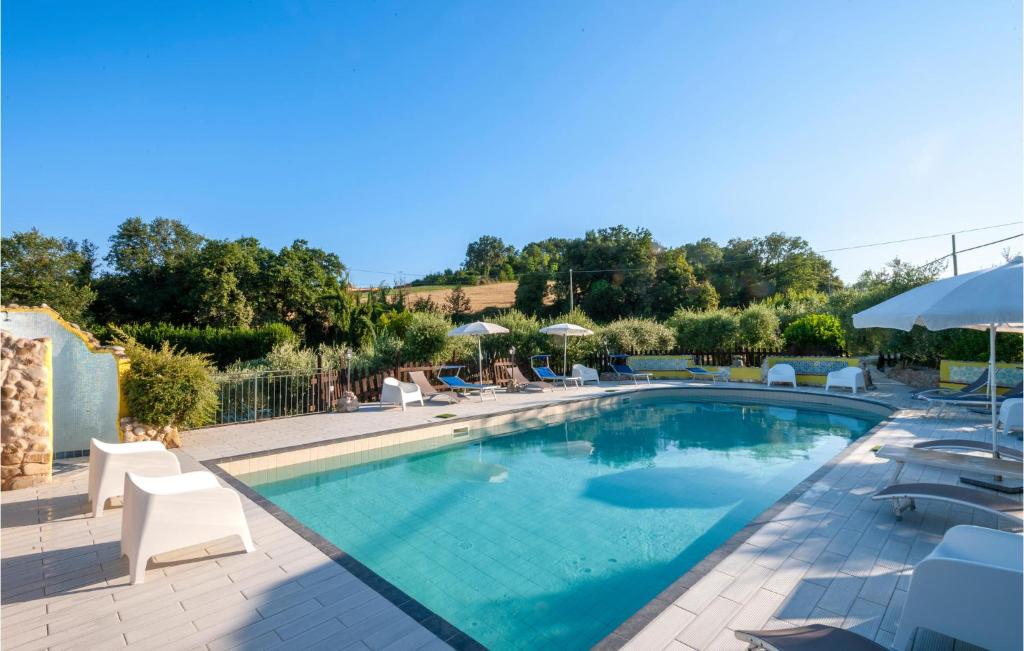 uma grande piscina com cadeiras e guarda-sóis em 2 Bedroom Pet Friendly Home In San Giovanni em Montefiore dellʼAso