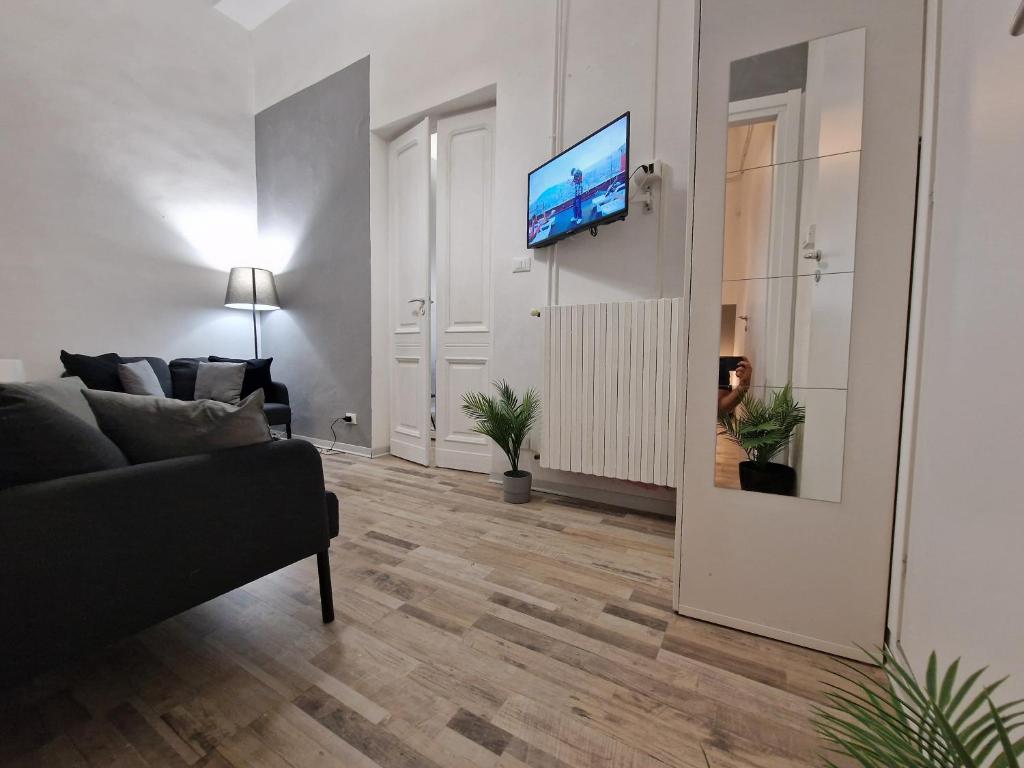 salon z kanapą i telewizorem na ścianie w obiekcie Casa Setter w Turynie
