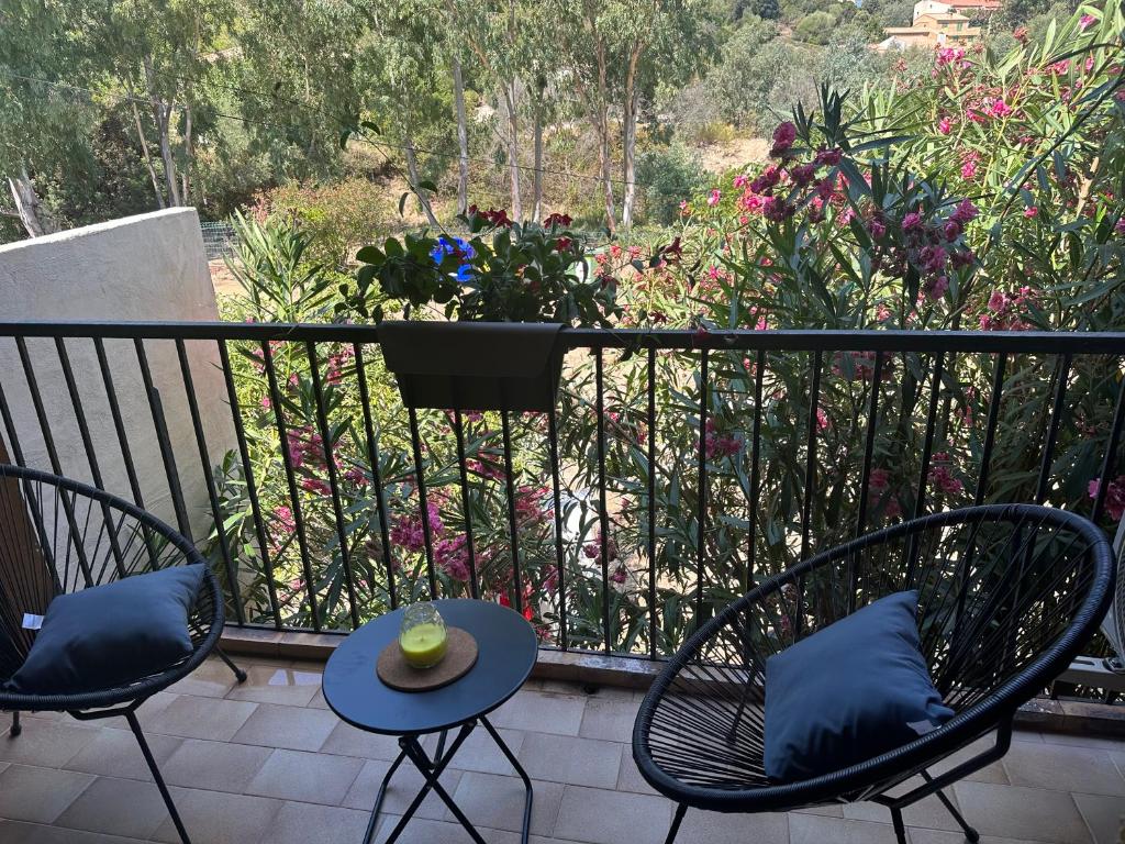 2 sillas y una mesa en un balcón con flores en Residence Palmarella appartement 9, en Galeria