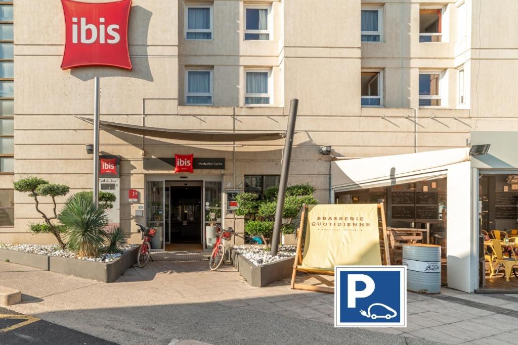 una tienda con un cartel delante de un edificio en ibis Montpellier Centre Polygone, en Montpellier