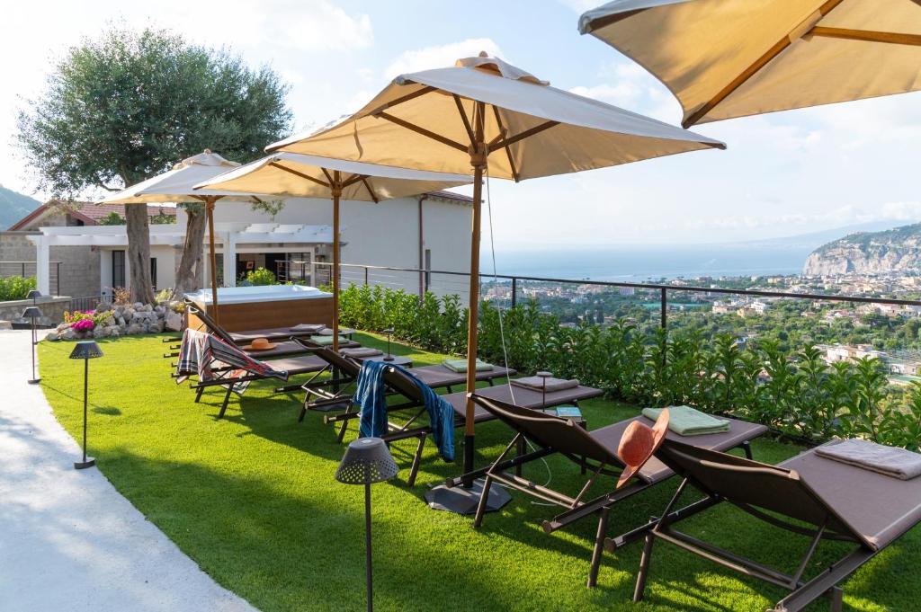 a patio with chairs and tables and umbrellas at Gargiulo Resort in Sant'Agnello