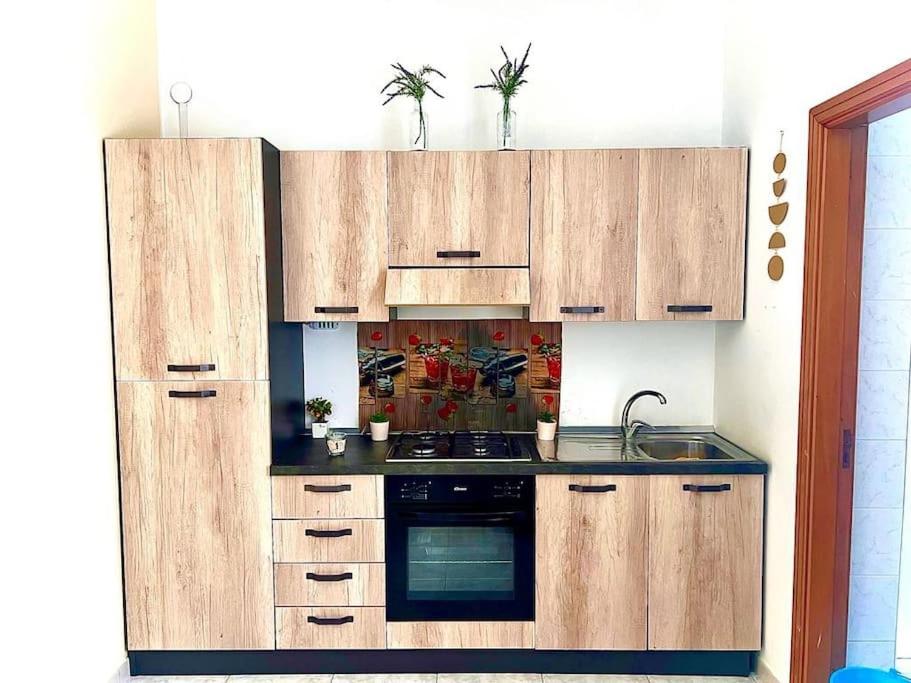 巴列塔的住宿－Casa Sant' Andrea，厨房配有木制橱柜和炉灶烤箱。