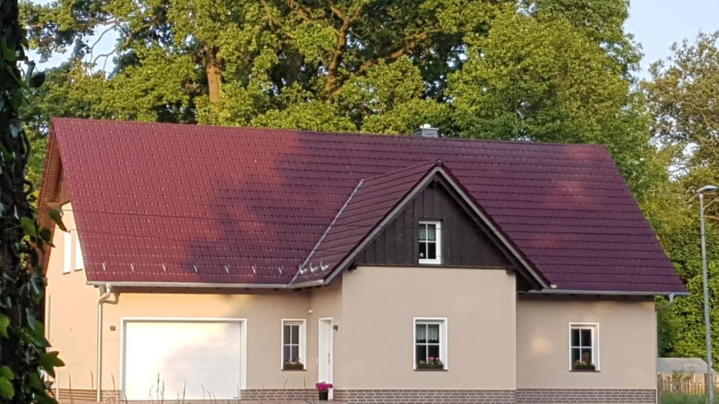 une maison blanche avec un toit rouge dans l'établissement Ferienwohnung Spreewaldglück, à Burg