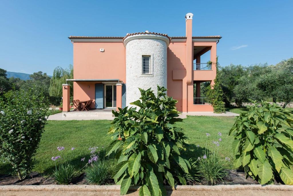 una casa con una torre en medio de un patio en Contemporary Corfu Retreat - 3 Bedrooms - Villa Girasole - Artful Decor - Lush Garden - Tranquil Setting en Dafnila