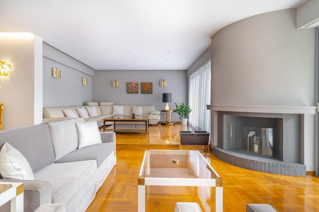uma sala de estar com um sofá e uma lareira em The HostMaster Luminous Elite Estate em Atenas