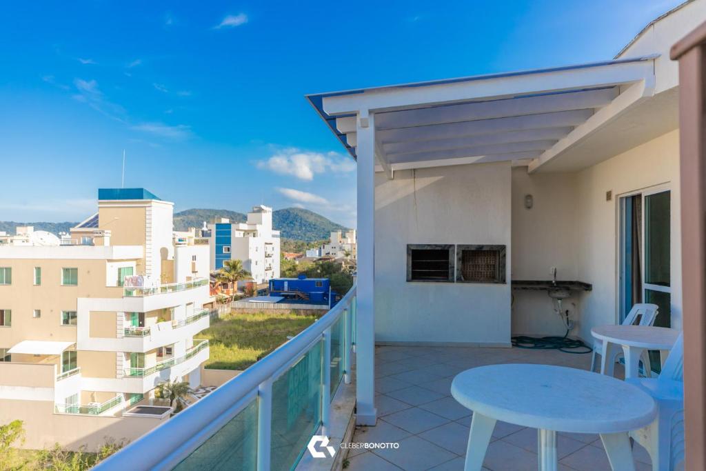 ein Balkon mit einem blauen Tisch und Stühlen auf einem Gebäude in der Unterkunft 150m do mar! Cobertura Duplex com Piscina Privada in Bombinhas