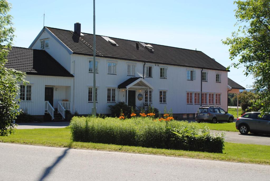 a white house with flowers in front of it at Grong Gård Guesthouse in Grong